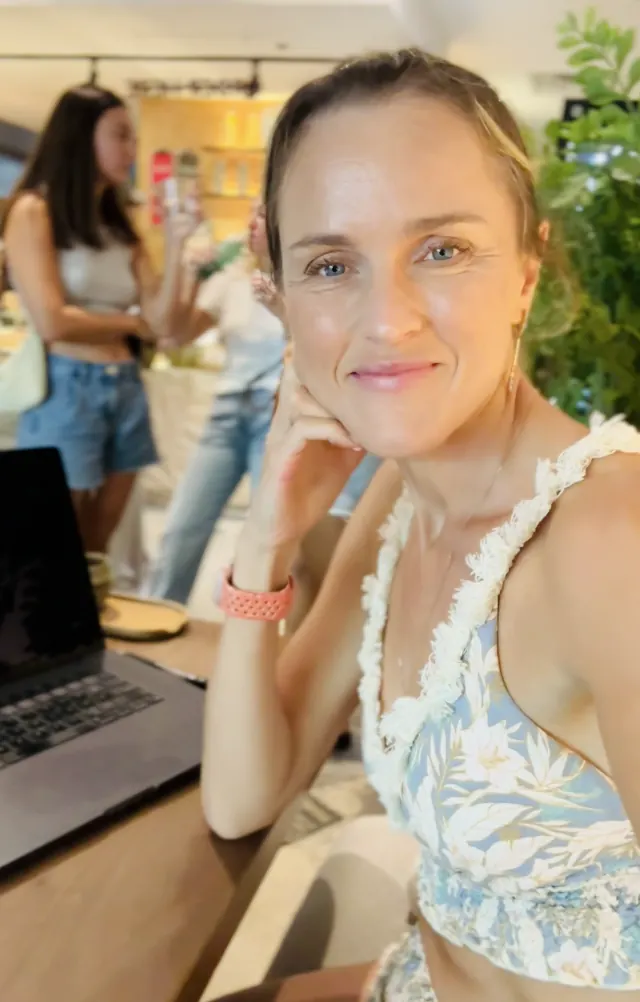 Maria Blair at a cafe table with her laptop open beside her